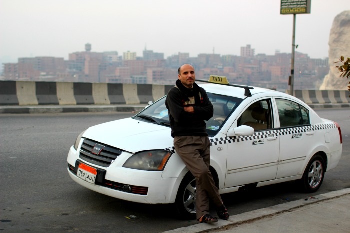 رجل يقف أمام التاكسي الخاص به