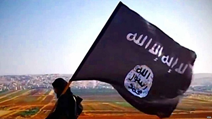 مقاتل من داعش يحمل علم لا إله إلا الله